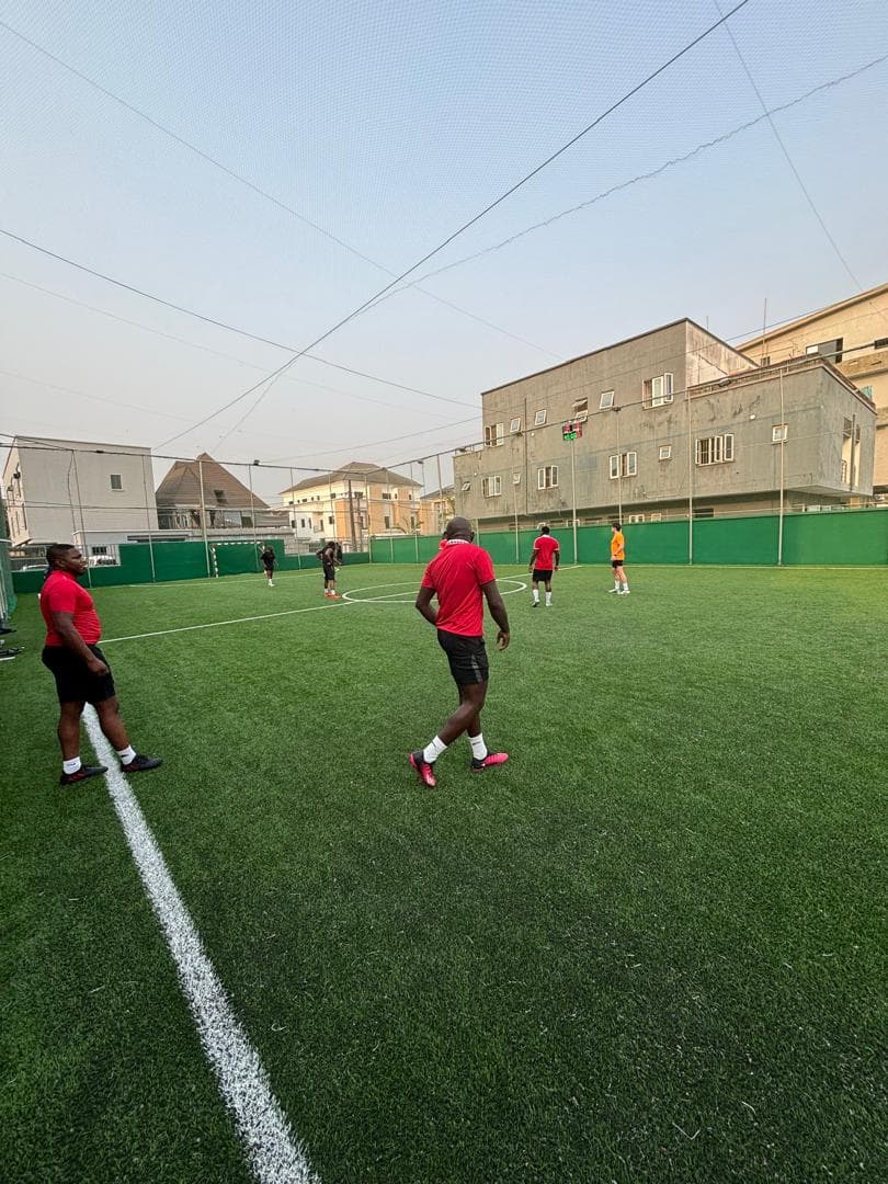 Players on a football pitch under floodlights